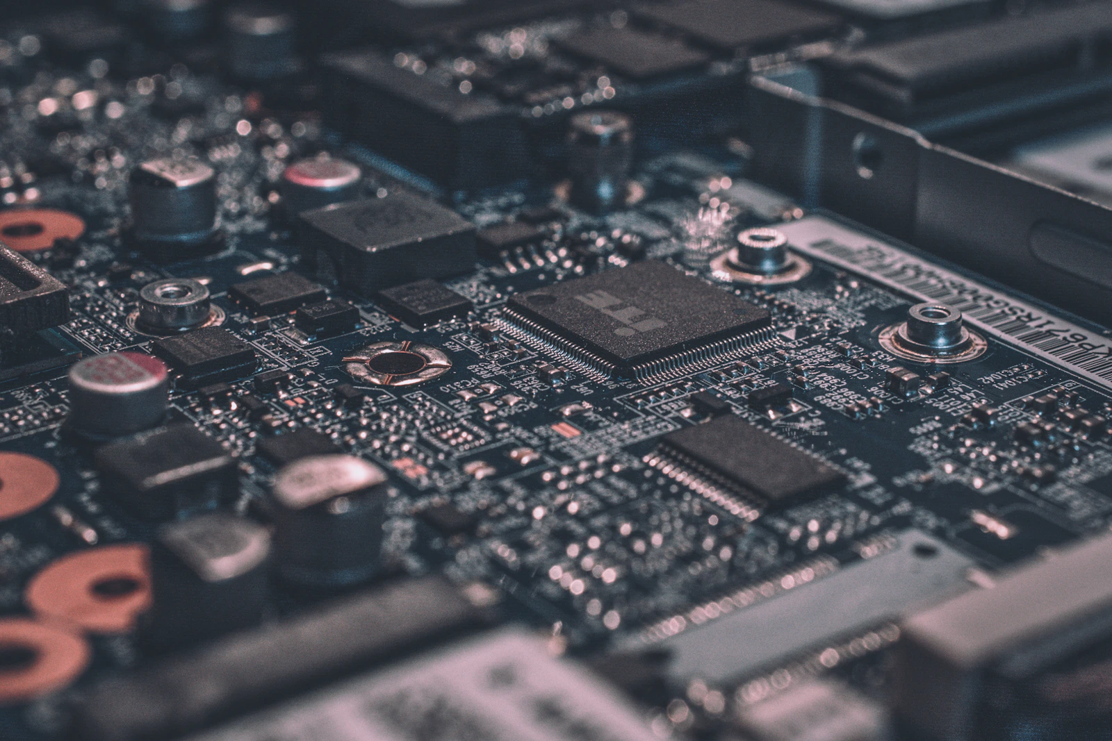 Detalhe aproximado de uma placa de circuito eletrônico em tons frios